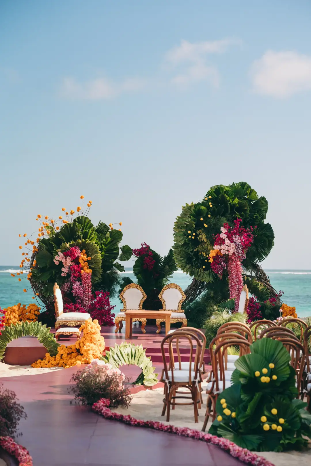 An oceanfront mandap dressed in marigolds and palm fronds