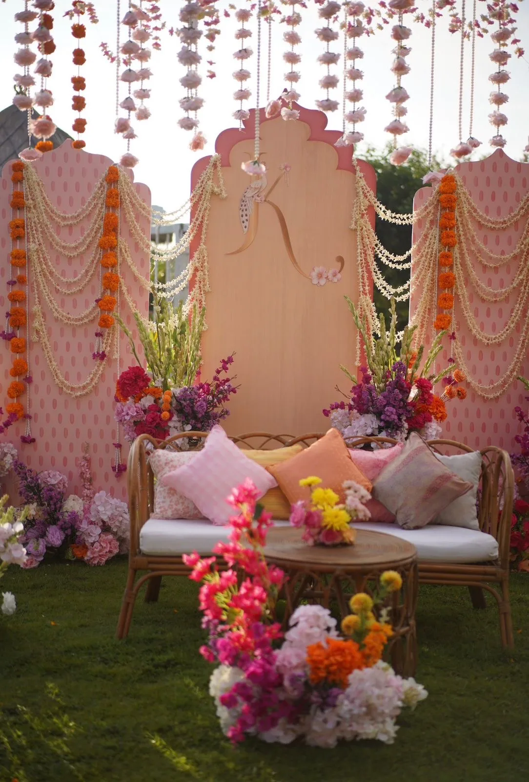 Monogrammed lounge backdrop with marigold and jasmine garlands at the mehndi setup