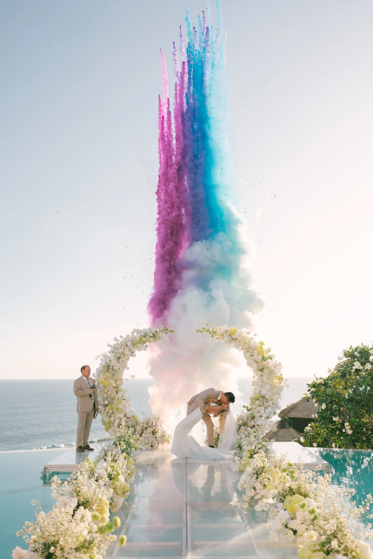 Juan and Shannon kiss beneath a cascade of coloured smoke above their clifftop ceremony