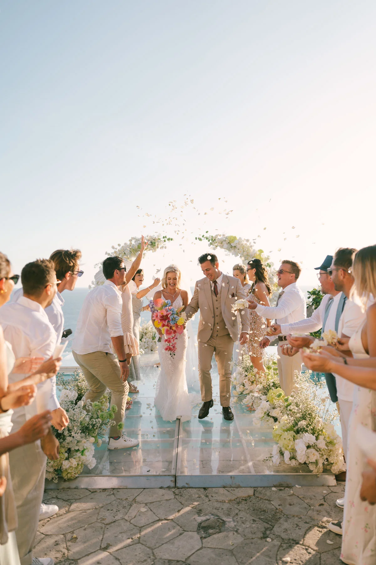 Petal confetti raining down on a couple walking back down the aisle