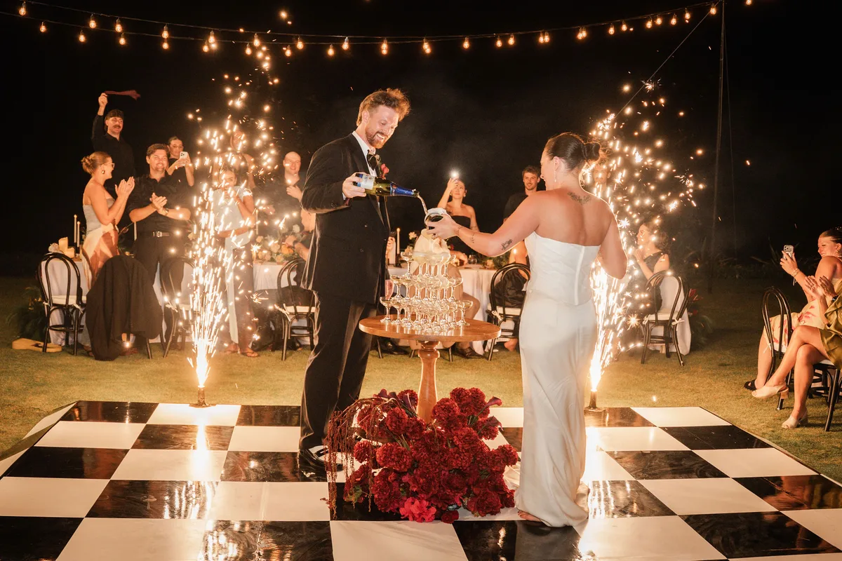 Kersten and William cutting their cake surrounded by cold sparklers at night