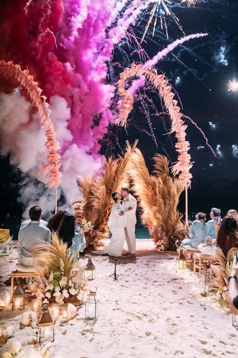 Fireworks lighting the night sky over a ceremony arch