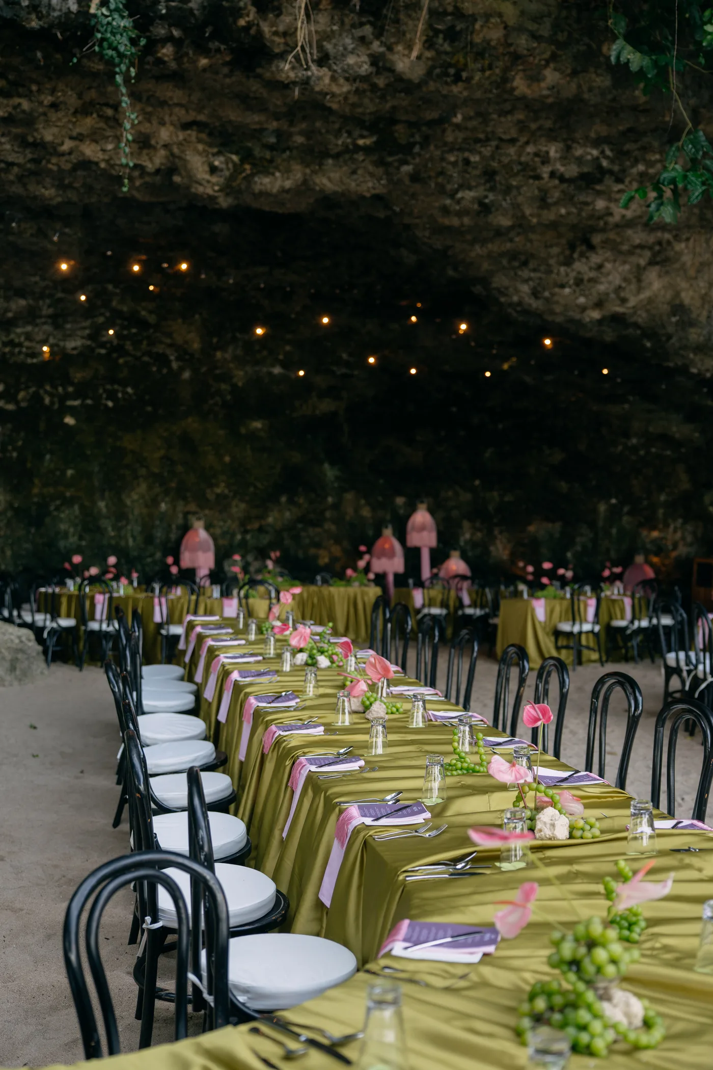 A candlelit long-table reception dinner inside a natural cave